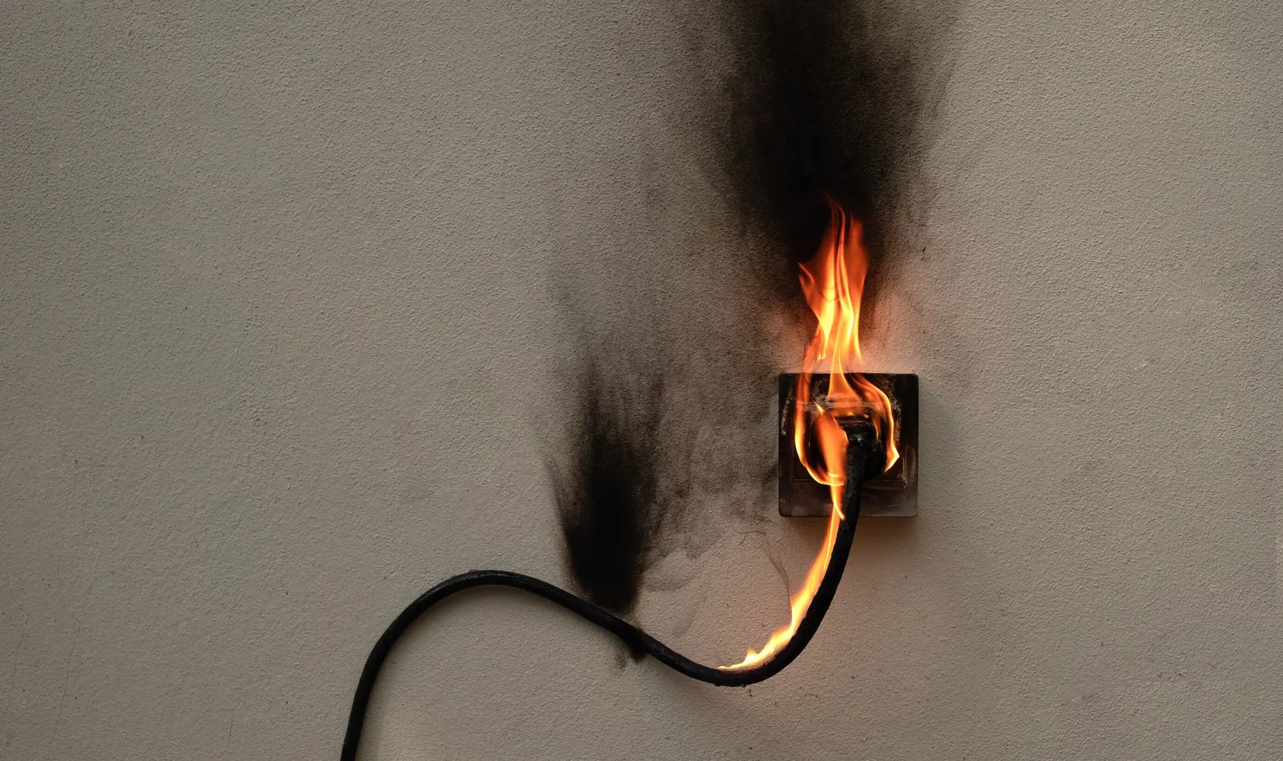 Verschmorte Steckdose mit Flammen: Brandgefahr durch alte Leitungen