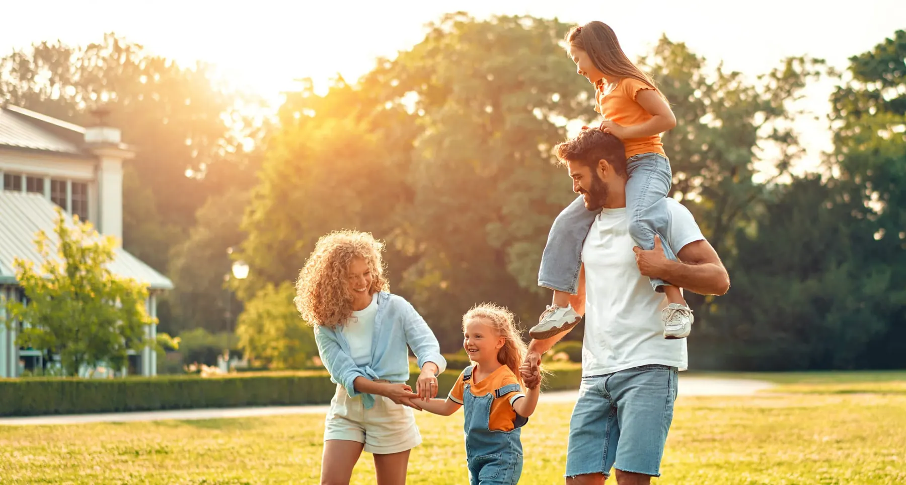 Familie im Garten vor dem Haus bei Sonnenuntergang